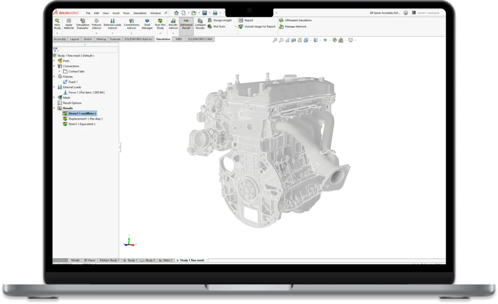 Laptop running CAD software with a wireframe engine model