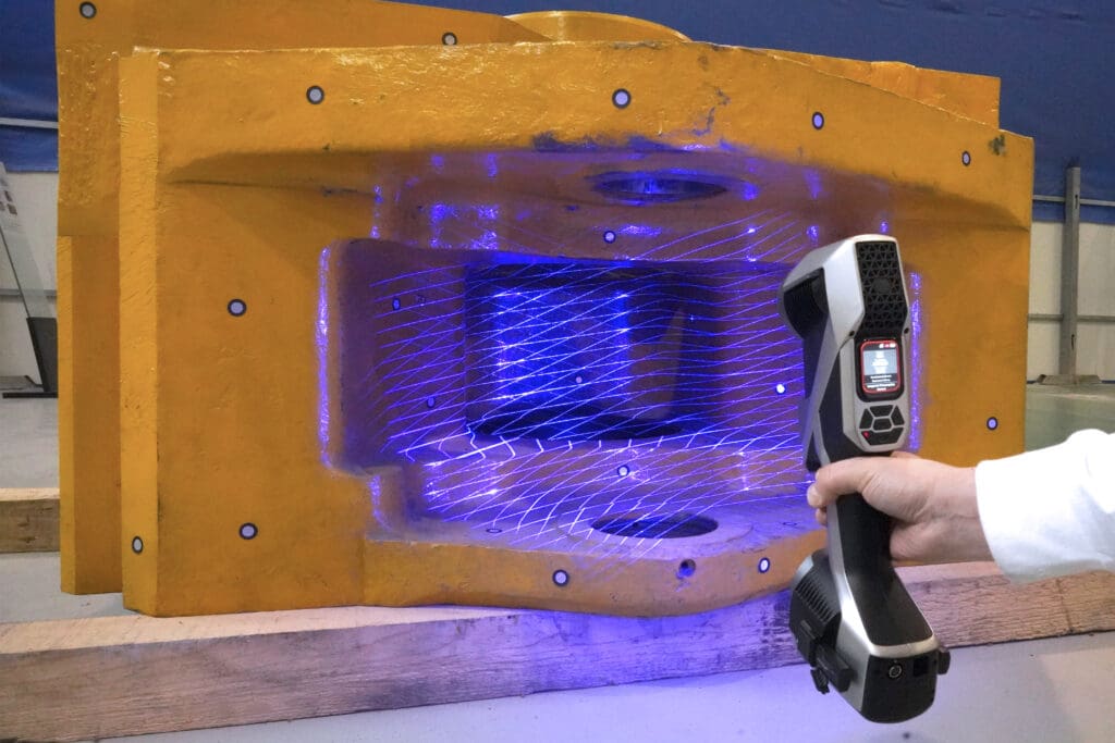 A man using a Scantech KSCAN X handheld 3D scanner to scan a large part with a deep crevice, demonstrating deep hole measurement capabilities with no blind spots.