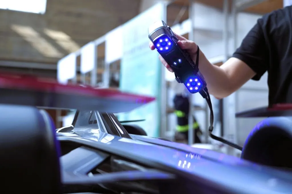 Simscan-S 3D handheld scanner being used to scan a large piece of metal in a shop