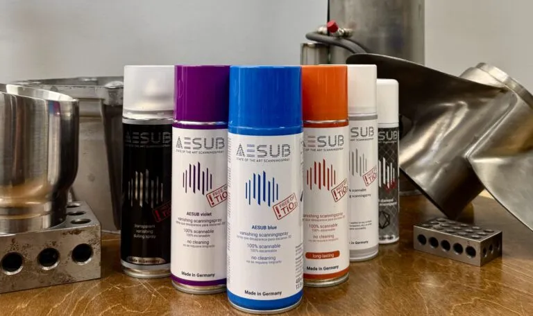 AESUB 3D scanning sprays in several colors next to shiny machined metal parts