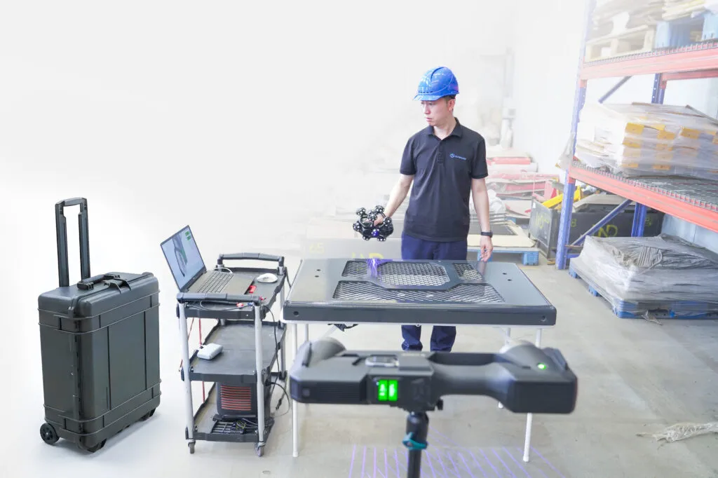 TrackScan GO tracker and scanner packed beside their single wheeled carrying case in a workshop, ready for one-person transport